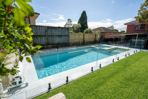 2023 NSW Best Fibreglass Pool over $80,000 award winner by Aquify Pools, featuring a luxurious pool and spa combination in East Ryde with a sunken dining area, fairy light adorned tree, and cozy fire pit, perfect for relaxation and entertainment - SPASA award winner featured on poolquotes.com.au