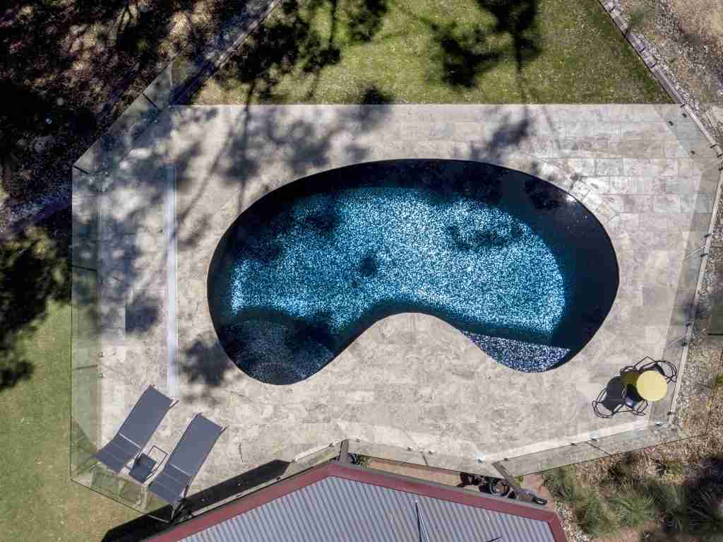 2023 SPASA award-winning freeform pool over $120,000 by Adelaide Classic Pools, featuring a stunning glass mosaic blend reflecting the natural surroundings of gum trees, koalas, and birds, perfect for a relaxing retreat.
