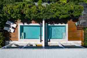 SPASA 2023 QLD Best Renovation award-winning project by Living Style Co, featuring two private courtyard pools created from a large shared pool, optimising the original structural footprint for privacy and style.