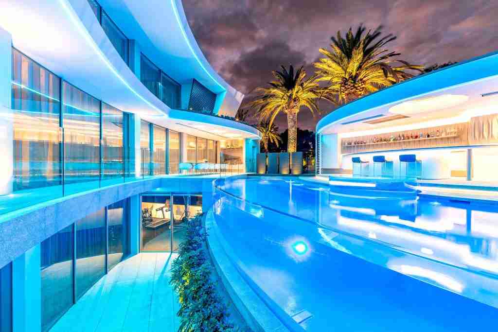 2023 SPASA award-winning concrete pool over $240,000 by Personal Pools featuring a 26.5m long design with full automation and acrylic windows overlooking lush greenery, showcased on poolquotes.com.au