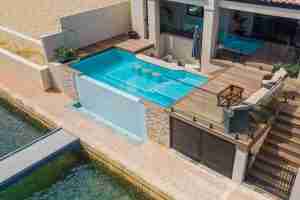 2023 WA Best Concrete Pool up to $60,000 award winner by Boardwalk Pools featuring a swim-up bar, infinity edge, turquoise mosaic tiles, DuraQuartz finish, and Viron Technology powered salt chlorinator and LED pool lights, all remotely operated - PoolQuotes.com.au
