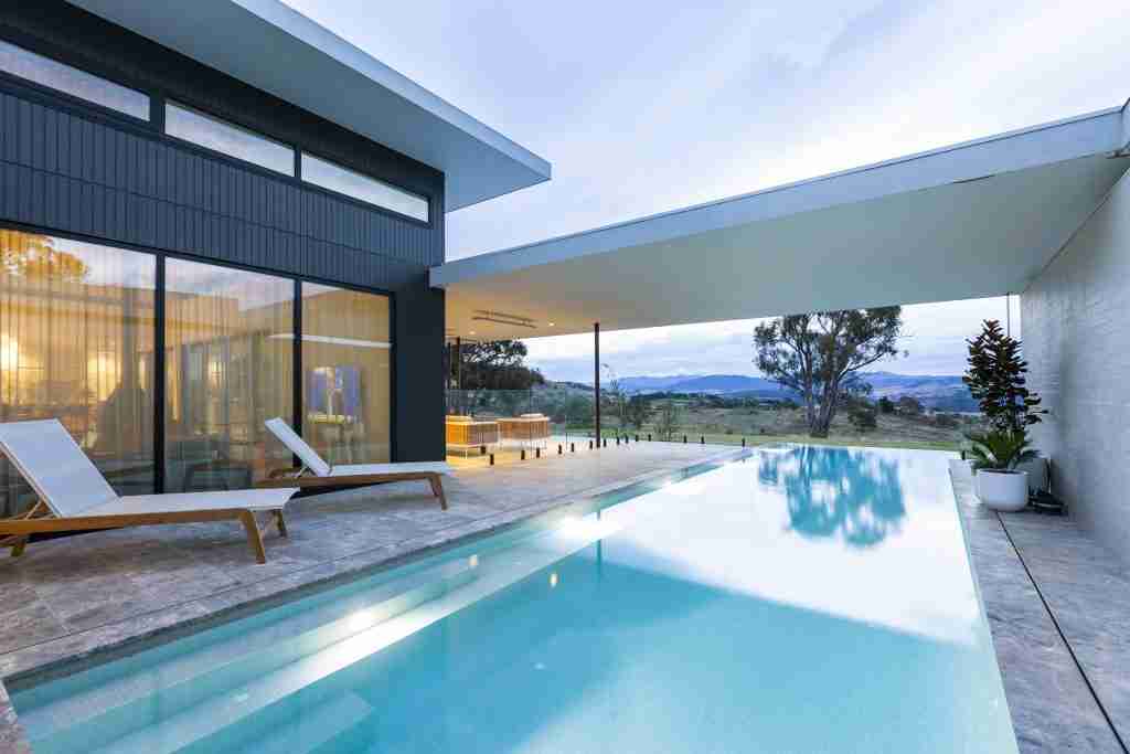 2023 ACT Best Concrete Lap Pool award winner by Leader Pools, featuring a stunning lap pool in a tranquil rural setting with the Brindabella Ranges and Murrumbidgee River in the backdrop, showcased on poolquotes.com.au